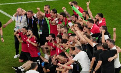Georgia's team and staff members celebrate at the end of a Group F match between Georgia and Portugal at the Euro 2024 soccer tournament in Gelsenkirchen, Germany, Wednesday, June 26, 2024. (AP Photo/Andreea Alexandru)