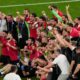Georgia's team and staff members celebrate at the end of a Group F match between Georgia and Portugal at the Euro 2024 soccer tournament in Gelsenkirchen, Germany, Wednesday, June 26, 2024. (AP Photo/Andreea Alexandru)