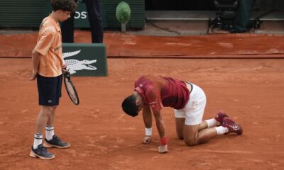 A ball kid came to the aid of Serbia's Novak Djokovic after he slipped and fell during his fourth round match of the French Open tennis tournament against Argentina's Francisco Cerundolo at the Roland Garros stadium in Paris, Monday, June 3, 2024. (AP Photo/Christophe Ena)