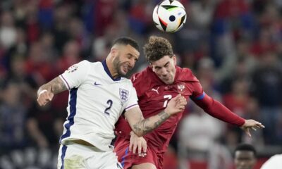 England's Kyle Walker, left, vies for a header next to Serbia's Dusan Vlahovic during the second half in a Group C match between Serbia and England at the Euro 2024 soccer tournament in Gelsenkirchen, Germany, Monday, June 17, 2024. (AP Photo/Thanassis Stavrakis)