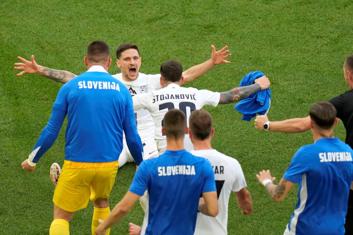 Slovenia's Erik Janza, on the ground, celebrates after scoring his side's first goal during a Group C match between Slovenia and Denmark at the Euro 2024 soccer tournament in Stuttgart, Germany, Sunday, June 16, 2024. (AP Photo/Ariel Schalit)