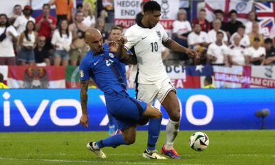 England's Jude Bellingham, right, moves the ball as Slovenia's Vanja Drkusic reaches in during a Group C match between the England and Slovenia at the Euro 2024 soccer tournament in Cologne, Germany, Tuesday, June 25, 2024. (AP Photo/Frank Augstein)