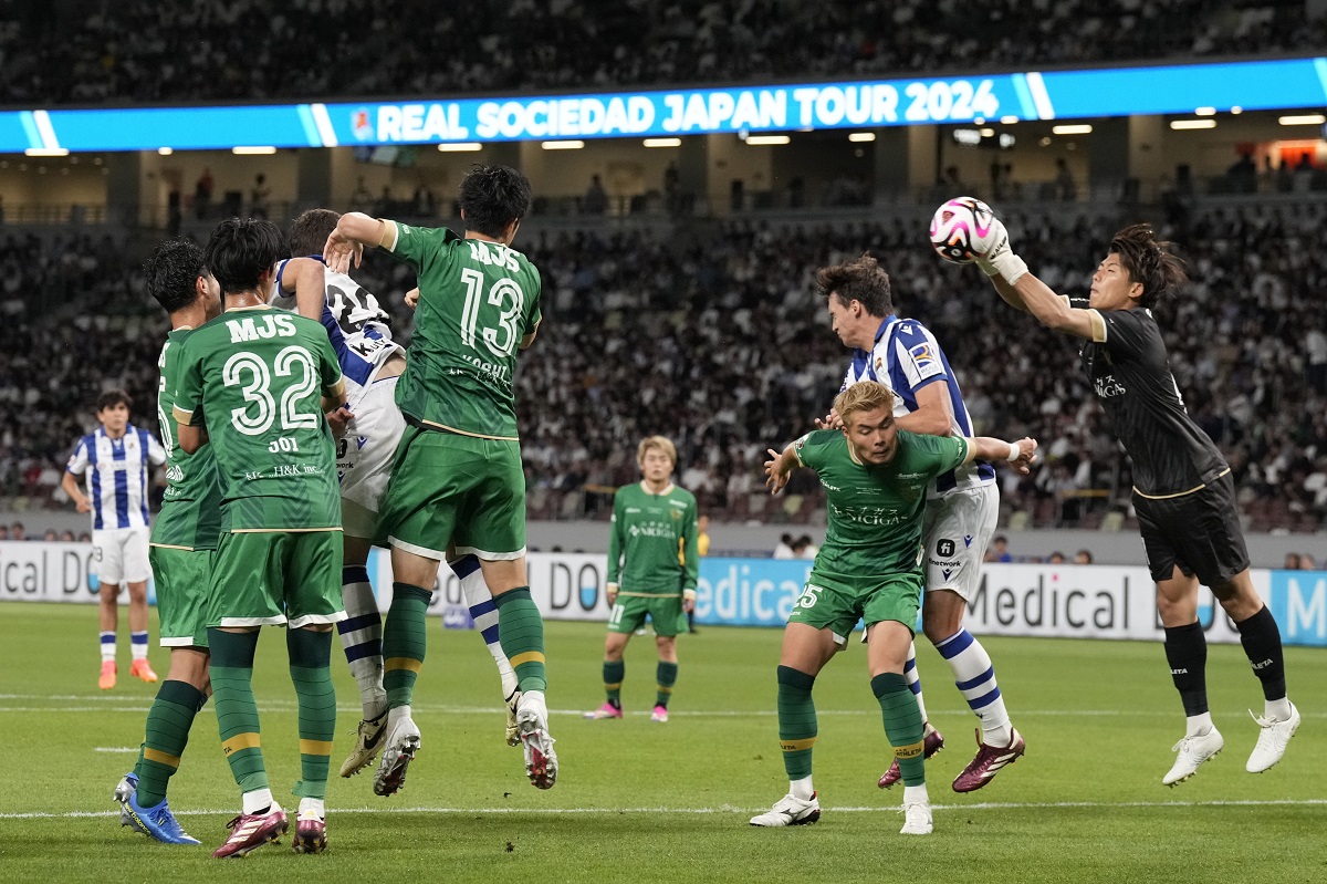 Tokyo Verdy's goalkeeper Yuya Nagasawa, right, makes a save during the friendly soccer match between Real Sociedad and Tokyo Verdy at the National Stadium Wednesday, May 29, 2024, in Tokyo. (AP Photo/Eugene Hoshiko)
