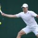 Miomir Kecmanovic of Serbia plays a forehand return to Sumit Nagal of India during their first round match of the Wimbledon tennis championships in London, Monday, July 1, 2024. (AP Photo/Kirsty Wigglesworth)
