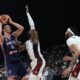 Serbia's Nikola Jokic, left, attempts to score as United States' Bam Adebayo blocks during an exhibition basketball match between Serbia and the United States at the USA Basketball Showcase, ahead of the 2024 Paris Olympic basketball tournament, in Abu Dhabi, United Arab Emirates, Wednesday, July 17, 2024. (AP Photo/Altaf Qadri)