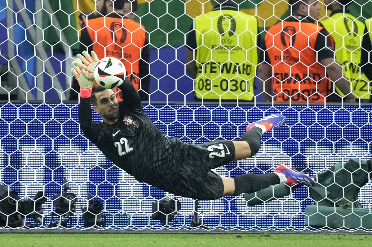 Portugal's goalkeeper Diogo Costa saves the ball during penalties of a round of sixteen match between Portugal and Slovenia at the Euro 2024 soccer tournament in Frankfurt, Germany, Monday, July 1, 2024. (AP Photo/Ebrahim Noroozi)