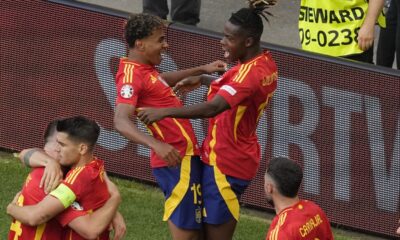 Spain's Lamine Yamal, top left celebrates with Spain's Nico Williams, top right and other team mates after Dani Olmo scored the opening goal during a quarter final match between Germany and Spain at the Euro 2024 soccer tournament in Stuttgart, Germany, Friday, July 5, 2024. (AP Photo/Michael Probst)