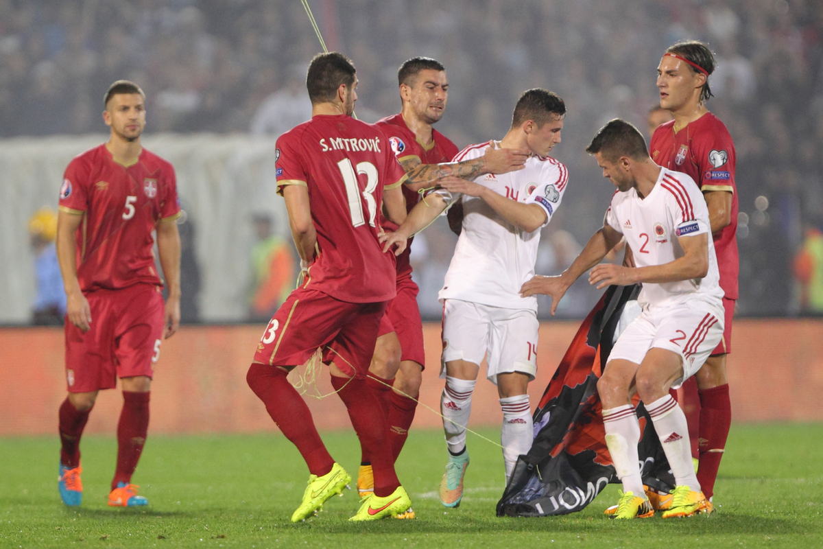 STEFAN MITROVIC, ALEKSANDAR KOLAROV, TAULANT XHAKA Taulant Caka, Zastava Velike Albanije koji vuce dron prekid tuca fudbaleri reprezentacije Srbije na utakmici kvalifikacija za UEFA Evropsko prvenstvo protiv Albanije na stadionu Partizana, Beograd 15.10.2014. godine Foto: Marko Metlas Fudbal, Reprezentacija, Srbija, Albanija, Kvalifikacije za Evropsko prvenstvo, Zastava, Dron, Tuca