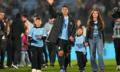 Uruguay's Luis Suarez waves to fans, accompanied by his children, after a qualifying soccer match for the FIFA World Cup 2026 against Paraguay, in Montevideo, Uruguay, Friday, Sept. 6, 2024. Suarez played his last game for Uruguay ending a 17 years international carrer. (AP Photo/Matilde Campodonico)