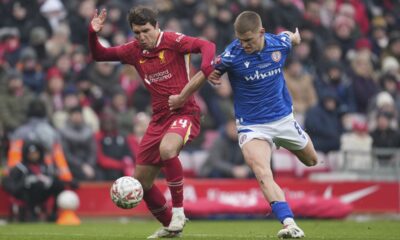 Liverpool's Federico Chiesa, left, and Accrington's Ben Woods vie for the ball during the FA Cup soccer match between Liverpool and Accrington Stanley at the Anfield stadium in Liverpool, England, Saturday, Jan. 11, 2025. (AP Photo/Jon Super)
