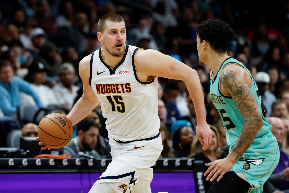 Denver Nuggets center Nikola Jokic (15) brings the ball up court against Charlotte Hornets guard KJ Simpson during the second half of an NBA basketball game in Charlotte, N.C., Saturday, Feb. 1, 2025. (AP Photo/Nell Redmond)