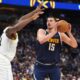 Denver Nuggets center Nikola Jokic, right, goes up for a basket as Utah Jazz center Oscar Tshiebwe, left, defends in the first half of an NBA basketball game Friday, March 28, 2025, in Denver. (AP Photo/David Zalubowski)