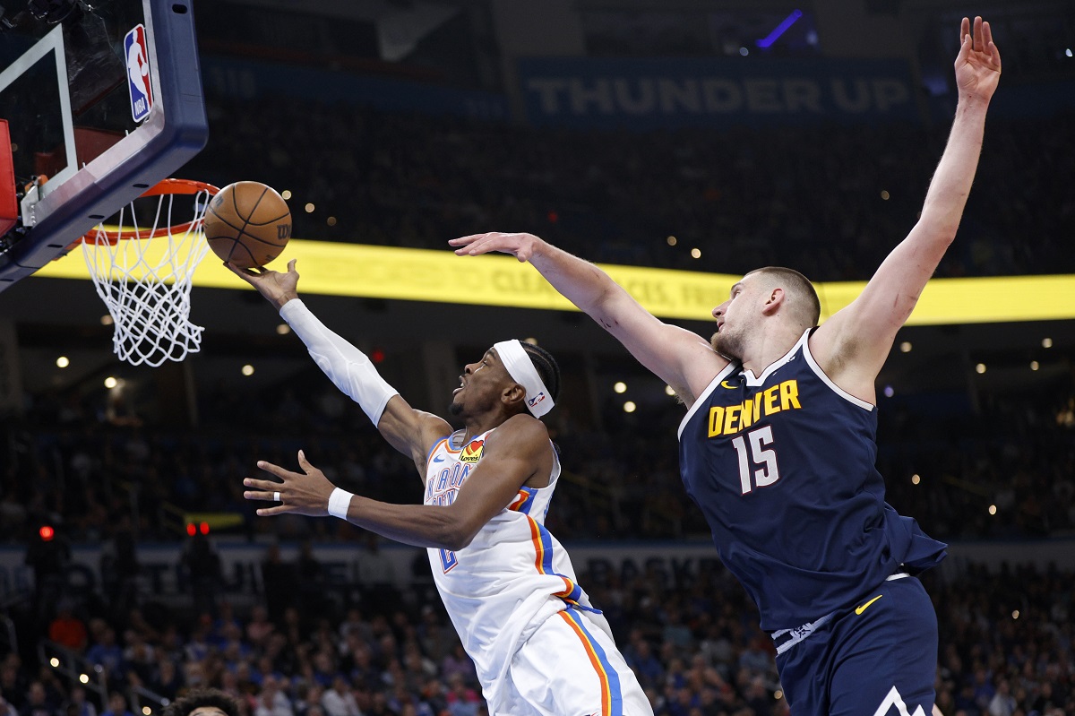 Oklahoma City Thunder guard Shai Gilgeous-Alexander, left, takes the ball to the basket in front of Denver Nuggets center Nikola Jokic (15) during the first half of an NBA basketball game Monday, March 10, 2025, in Oklahoma City. (AP Photo/Nate Billings)