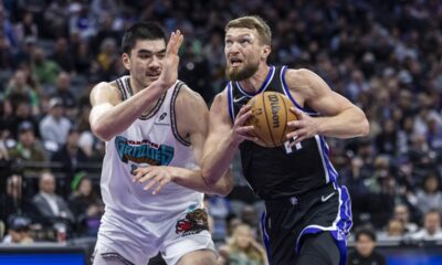 Sacramento Kings center Domantas Sabonis, right, makes a driving layup on Memphis Grizzlies center Zach Edey, left, during the first half of an NBA basketball game Monday, March 17, 2025, in Sacramento, Calif. (AP Photo/Sara Nevis)