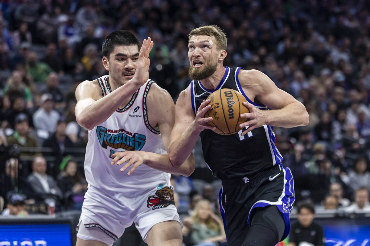Sacramento Kings center Domantas Sabonis, right, makes a driving layup on Memphis Grizzlies center Zach Edey, left, during the first half of an NBA basketball game Monday, March 17, 2025, in Sacramento, Calif. (AP Photo/Sara Nevis)