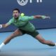 Novak Djokovic, of Serbia, hits a return to Rinky Hijikata, of Australia, during the Miami Open tennis tournament, Friday, March 21, 2025, in Miami Gardens, Fla. (AP Photo/Lynne Sladky)