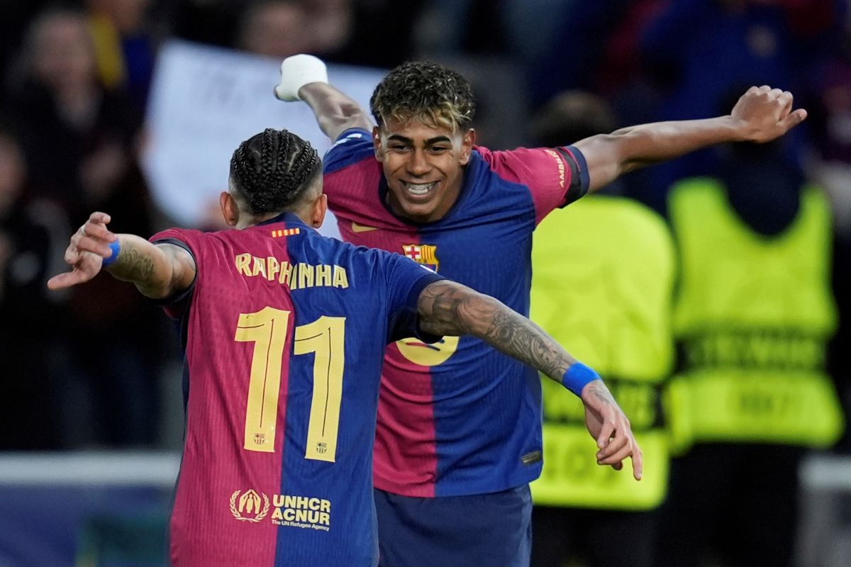 Barcelona's Raphinha, left, celebrates with his teammate Lamine Yamal after scoring his side's opening goal during the Champions League round of 16 second leg soccer match between FC Barcelona and SL Benfica at the Lluis Companys Olympic Stadium in Barcelona, Spain, Tuesday, March 11, 2025. (AP Photo/Emilio Morenatti)