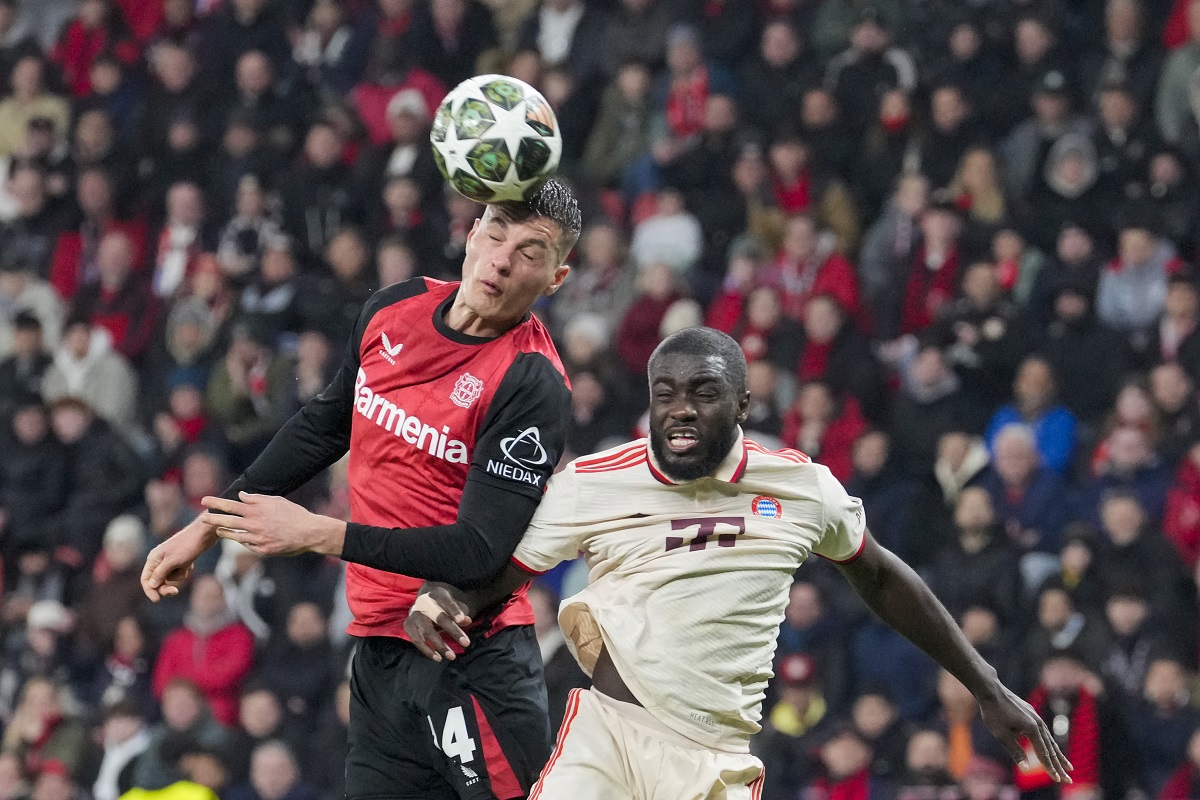 Leverkusen's Patrik Schick, left, jumps for the ball with Bayern's Dayot Upamecano during the Champions League round of 16 second leg soccer match between Bayer Leverkusen and Bayern Munich at the BayArena in Leverkusen, Germany, Tuesday, March 11, 2025. (AP Photo/Martin Meissner)