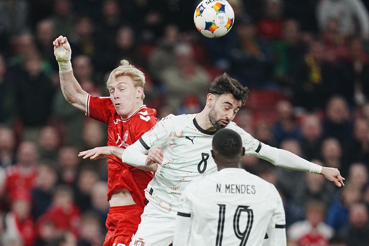 Denmark's Mika Biereth, left, and Portugals Bruno Fernandes vie for the ball during the Nations League playoff soccer match between Denmark and Portugal at Parken in Copenhagen, Thursday, March 20, 2024. (Liselotte Sabroe/Ritzau Scanpix via AP)