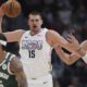 Denver Nuggets center Nikola Jokic, left, fields a pass as Milwaukee Bucks center Brook Lopez defends in the first half of an NBA basketball game Wednesday, March 26, 2025, in Denver. (AP Photo/David Zalubowski)