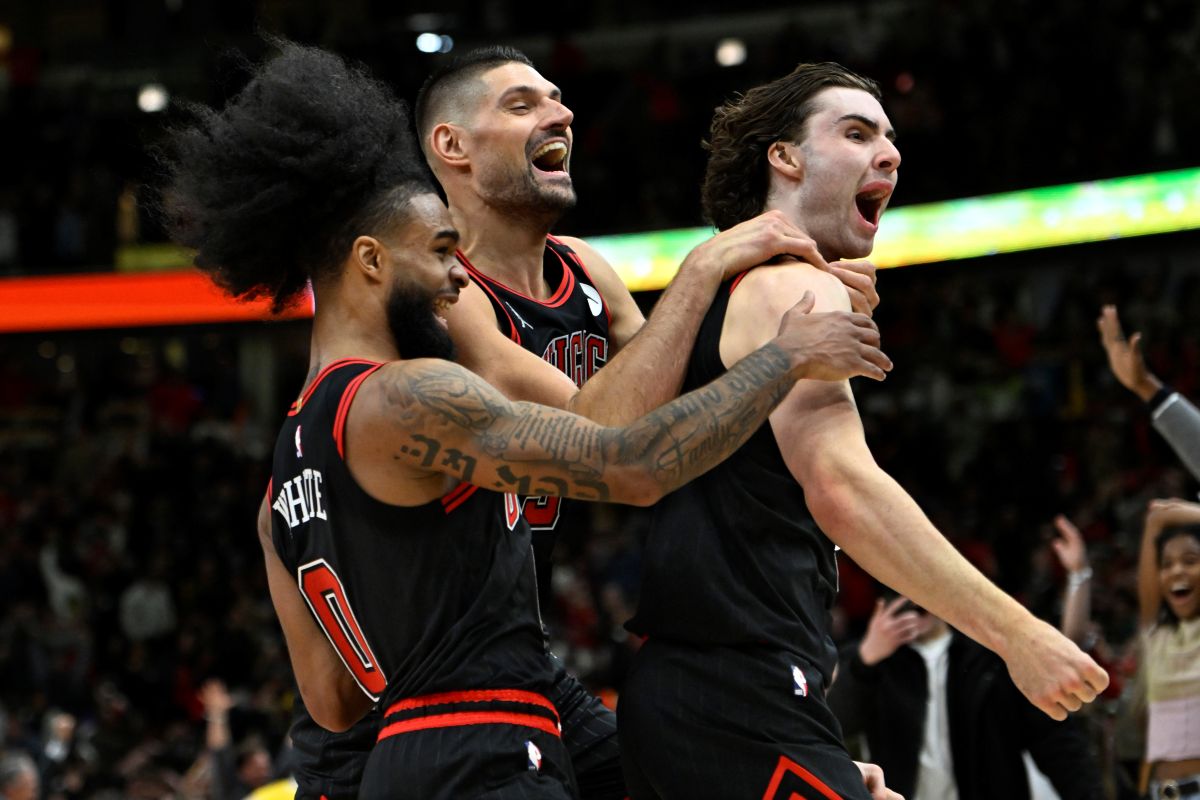 Chicago Bulls' Josh Giddey right, celebrates with teammates Nikola Vucevic center, and Coby White left, after making the winning basket against the Los Angeles Lakers in an NBA basketball game Thursday, March 27, 2025, in Chicago. (AP Photo/Paul Beaty)