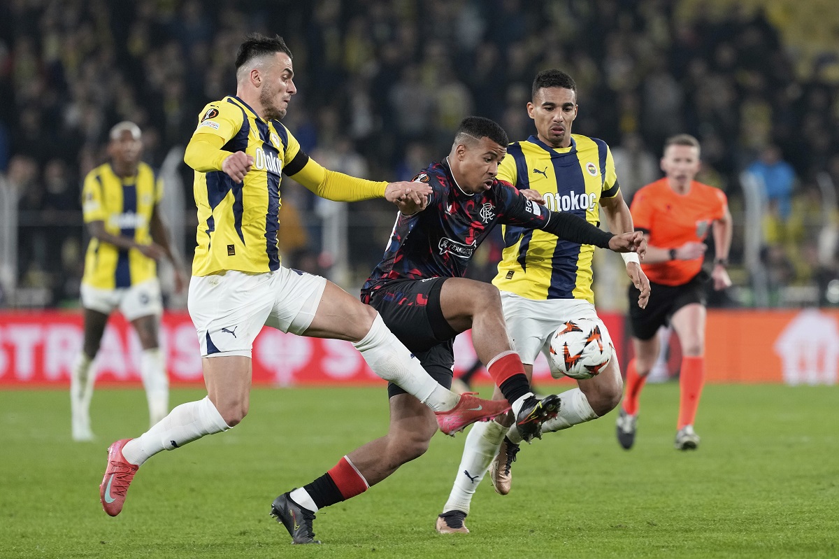 Rangers' Hamza Igamane, center, is challenged by Fenerbahce's Filip Kostic, left, and Fenerbahce's Alexander Djiku during the Europa League round of 16 first leg soccer match between Fenerbahce and Rangers at Sukru Saracoglu stadium in Istanbul, Turkey, Thursday, March 6, 2025. (AP Photo/Khalil Hamra)