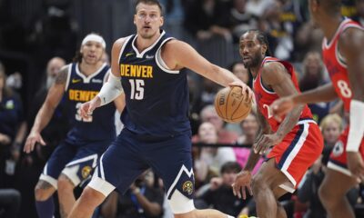 Denver Nuggets center Nikola Jokic, left, collects a loose ball as Los Angeles Clippers forward Kawhi Leonard defends in the second half of Game 2 of a first-round NBA playoff series Monday, April 21, 2025, in Denver. (AP Photo/David Zalubowski)