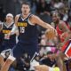 Denver Nuggets center Nikola Jokic, left, collects a loose ball as Los Angeles Clippers forward Kawhi Leonard defends in the second half of Game 2 of a first-round NBA playoff series Monday, April 21, 2025, in Denver. (AP Photo/David Zalubowski)