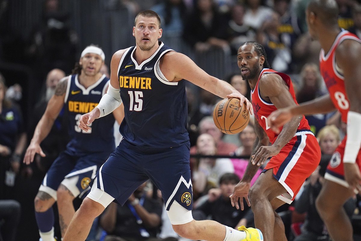 Denver Nuggets center Nikola Jokic, left, collects a loose ball as Los Angeles Clippers forward Kawhi Leonard defends in the second half of Game 2 of a first-round NBA playoff series Monday, April 21, 2025, in Denver. (AP Photo/David Zalubowski)