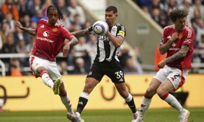 Manchester United's Leny Yoro, left, and Victor Lindelof, right, challenge for the ball with Newcastle United's Bruno Guimaraes, center, during the English Premier League soccer match between Newcastle United and Manchester United in Newcastle upon Tyne, England, Sunday, April 13, 2025. (Owen Humphreys/PA via AP)
