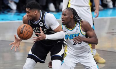 Milwaukee Bucks' Giannis Antetokounmpo, left, tries to keep control of the ball as Indiana Pacers' Aaron Nesmith, right, defends during the first half of a first-round NBA basketball playoff game, Saturday, April 19, 2025, in Indianapolis. (AP Photo/Michael Conroy)