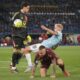 Roma's goalkeeper Mile Svilar, left, and Lazio's Gustav Isaksen during the Italian Serie A soccer match between Lazio and Roma at Rome's Olympic stadium, Sunday, April 13, 2025. (AP Photo/Gregorio Borgia)