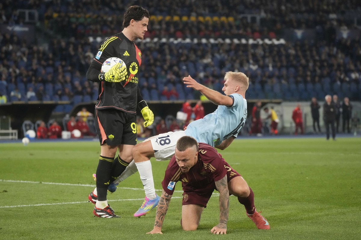Roma's goalkeeper Mile Svilar, left, and Lazio's Gustav Isaksen during the Italian Serie A soccer match between Lazio and Roma at Rome's Olympic stadium, Sunday, April 13, 2025. (AP Photo/Gregorio Borgia)