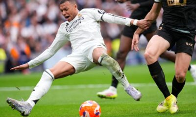 Real Madrid's Kylian Mbappe, left, falls chased by Valencia's Cesar Tarrega during a Spanish La Liga soccer match between Real Madrid and Valencia at the Santiago Bernabeu stadium in Madrid, Spain, Saturday, April 5, 2025. (AP Photo/Manu Fernandez)
