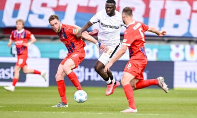 Leverkusen's Victor Boniface, center, is caught between Heidenheim's Patrick Mainka, left, and Benedikt Gimber during the German Bundesliga soccer match between 1. FC Heidenheim and Bayer Leverkusen, at the Voith-Arena in Heidenheim, Germany, Saturday, April 5, 2025. (Harry Langer/dpa via AP)