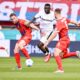Leverkusen's Victor Boniface, center, is caught between Heidenheim's Patrick Mainka, left, and Benedikt Gimber during the German Bundesliga soccer match between 1. FC Heidenheim and Bayer Leverkusen, at the Voith-Arena in Heidenheim, Germany, Saturday, April 5, 2025. (Harry Langer/dpa via AP)
