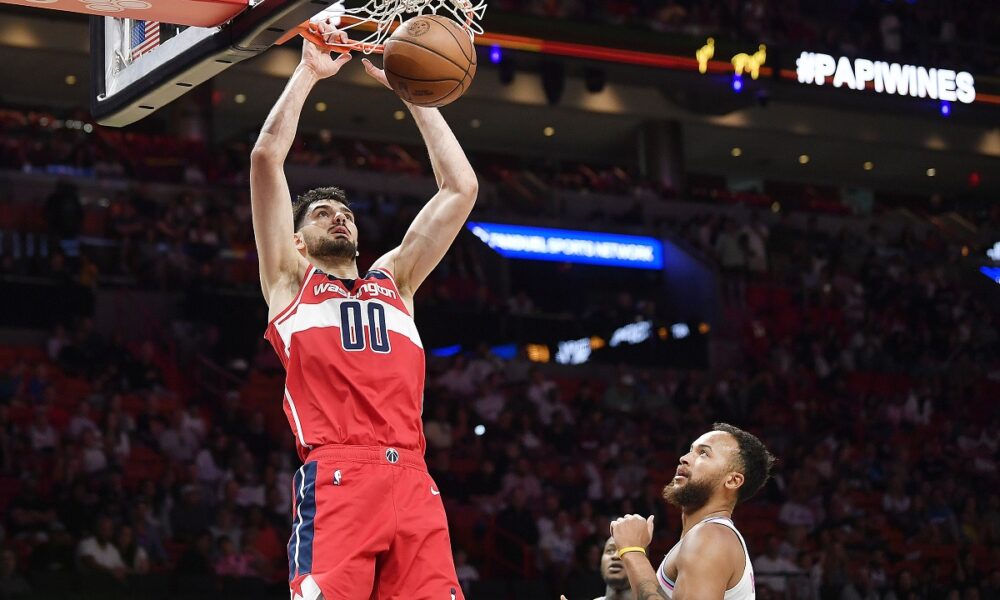 Washington Wizards forward Tristan Vukcevic (00) scores over Miami Heat forward Kyle Anderson during the first half of a NBA basketball game, Sunday, April 13, 2025, in Miami. (AP Photo/Michael Laughlin)