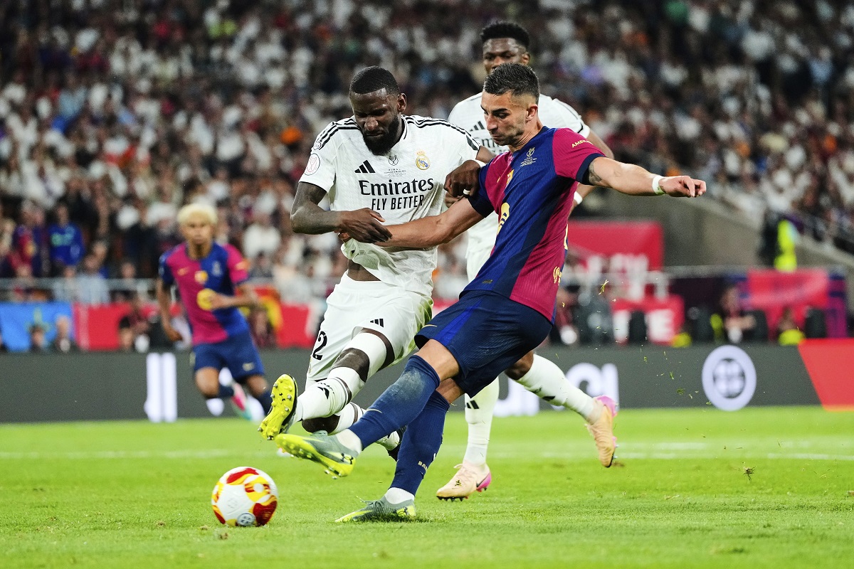 Real Madrid's Antonio Rudiger, left, challenges for the ball with Barcelona's Ferran Torres during the Spanish Copa del Rey final soccer match between Barcelona and Real Madrid at Estadio de La Cartuja stadium in Seville, Spain, Sunday, April 27, 2025. (AP Photo/Jose Breton)