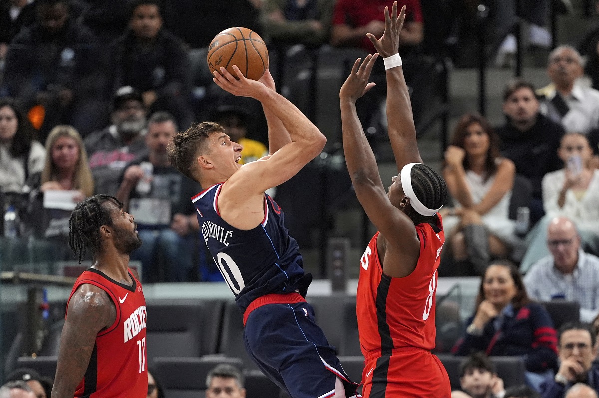 Los Angeles Clippers guard Bogdan Bogdanovic, center, shoots as Houston Rockets forward Tari Eason, left, and forward Jae'Sean Tate defend during the first half of an NBA basketball game Wednesday, April 9, 2025, in Inglewood, Calif. (AP Photo/Mark J. Terrill)