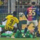 Barcelona's goalkeeper Wojciech Szczesny, center, makes a save in front of Dortmund's Serhou Guirassy, left, during the Champions League quarterfinals second leg soccer match between Borussia Dortmund and Barcelona, at the Signa-Iduna Park in Dortmund, Germany, Tuesday, April 15, 2025. (AP Photo/Martin Meissner)