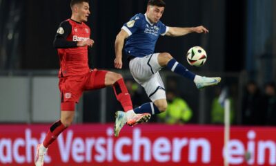 Leverkusen's Patrik Schick, left, and Bielefeld's Stefano Russo fight for the ball during the German soccer cup, DFB Pokal, semi-final soccer match between Arminia Bielefeld and Bayer Leverkusen in Bielefeld, Germany, Tuesday, April 1, 2025. (Friso Gentsch/dpa via AP)