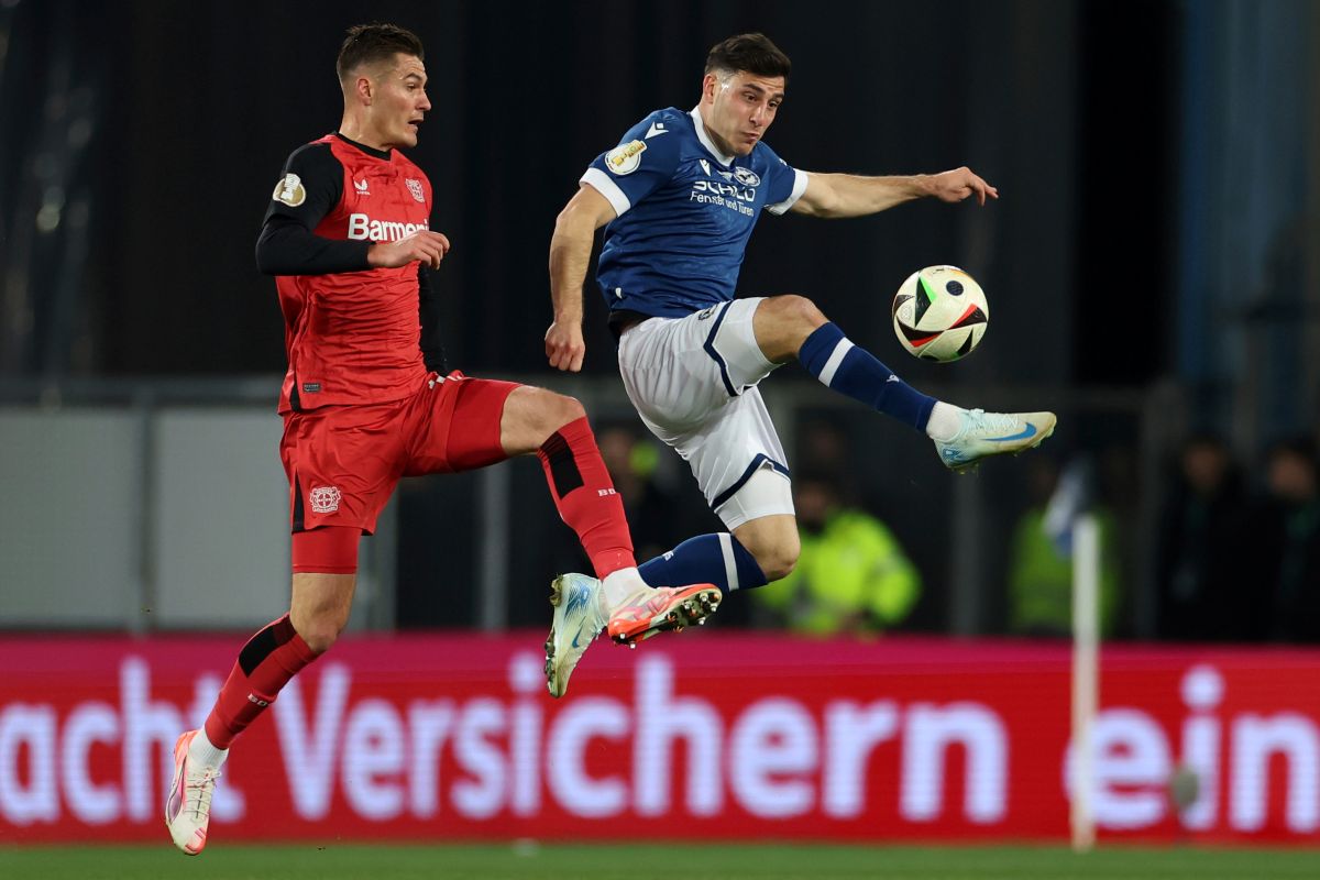 Leverkusen's Patrik Schick, left, and Bielefeld's Stefano Russo fight for the ball during the German soccer cup, DFB Pokal, semi-final soccer match between Arminia Bielefeld and Bayer Leverkusen in Bielefeld, Germany, Tuesday, April 1, 2025. (Friso Gentsch/dpa via AP)