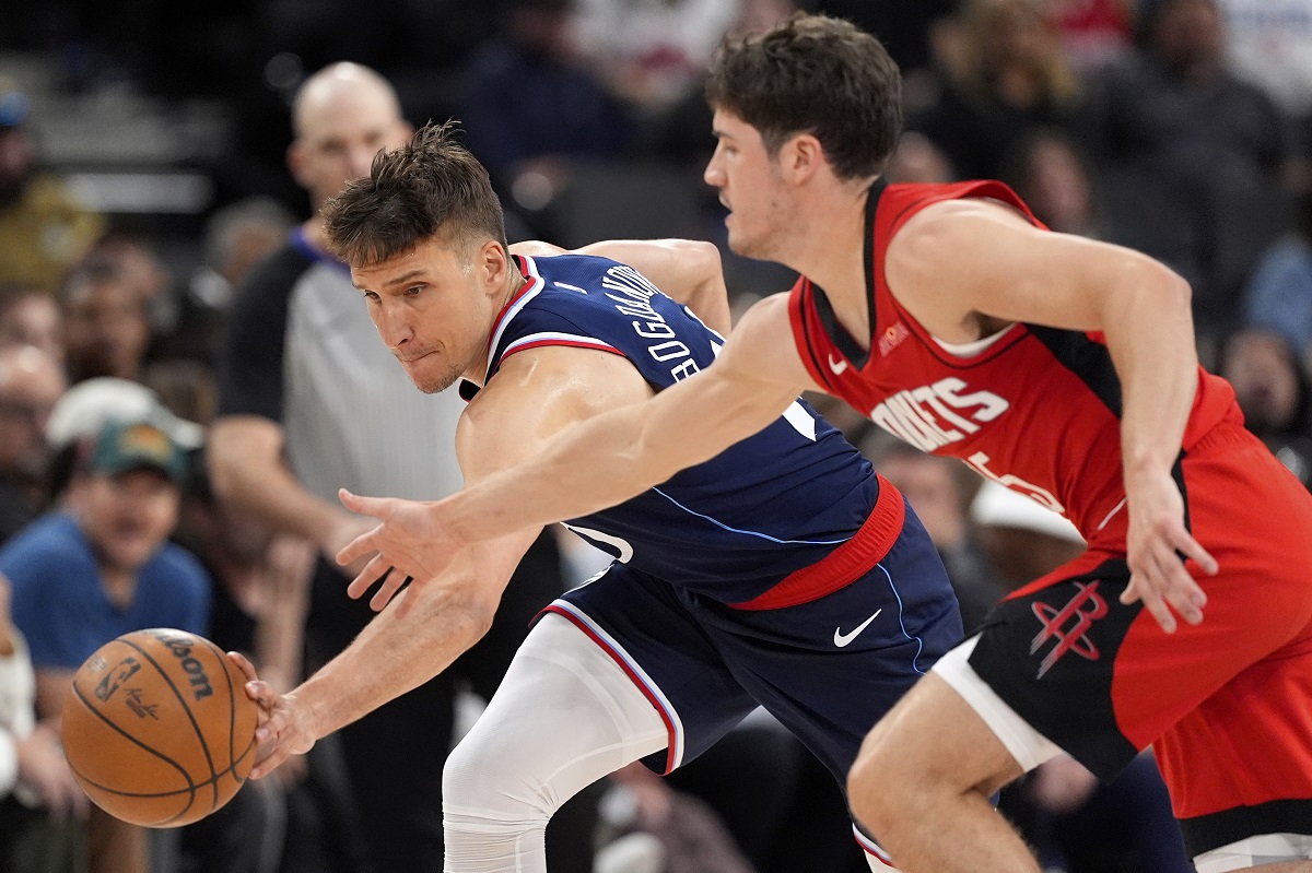 Los Angeles Clippers guard Bogdan Bogdanovic, left, and Houston Rockets guard Reed Sheppard reach for a loose ball during the second half of an NBA basketball game Wednesday, April 9, 2025, in Inglewood, Calif. (AP Photo/Mark J. Terrill)