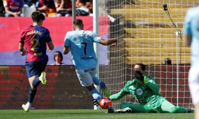 Barcelona's Pau Cubarsi, left, challenges for the ball with Celta's Borja Iglesias during a Spanish La Liga soccer match between Barcelona and Celta de Vigo at the Lluis Companys Olympic stadium in Barcelona, Spain, Saturday, April 19, 2025. (AP Photo/Joan Monfort)