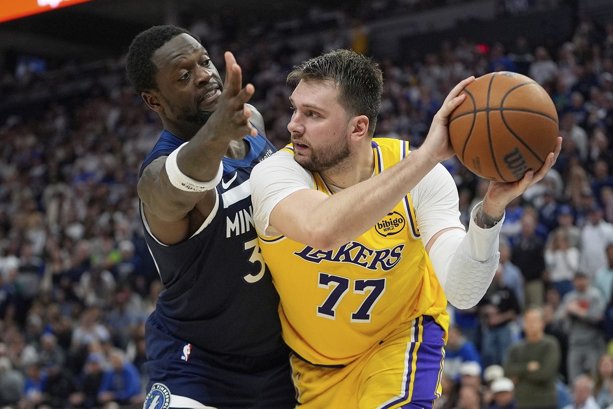 Los Angeles Lakers guard Luka Doncic (77) looks to pass as Minnesota Timberwolves forward Julius Randle (30) defends during the second half of Game 3 of an NBA basketball first-round playoff series, Friday, April 25, 2025, in Minneapolis. (AP Photo/Abbie Parr)