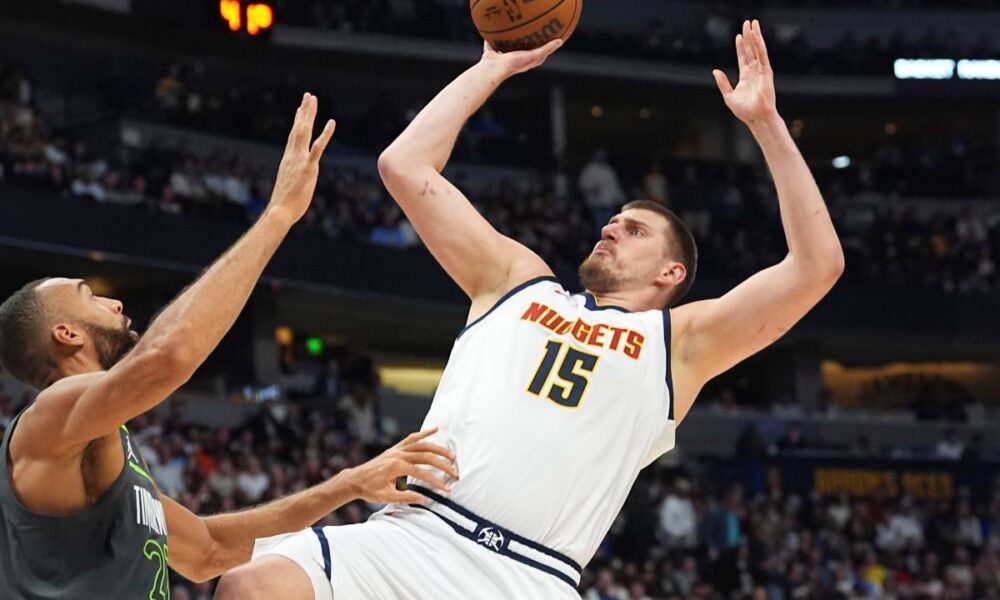 Denver Nuggets center Nikola Jokic, right, shoots for a basket over Minnesota Timberwolves center Rudy Gobert in the first half of an NBA basketball game Tuesday, April 1, 2025, in Denver. (AP Photo/David Zalubowski)