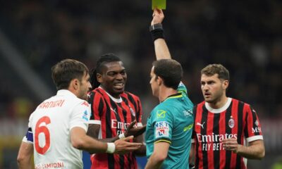 Referee Giovanni Ayroldi shows a yellow card to AC Milan's Rafael Leao during the Italian Serie A soccer match between AC Milan and Fiorentina at the San Siro Stadium in Milan, Italy, Saturday, April 5, 2025. (AP Photo/Antonio Calanni)