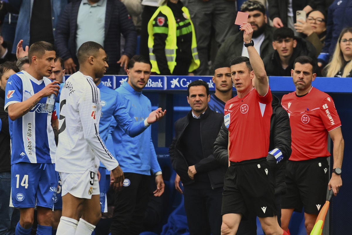 Real Madrid's Kylian Mbappe, 2nd left is shown a red card by the referee during a Spanish La Liga soccer match between Alaves and Real Madrid at the Mendizorroza stadium in Vitoria, Spain, Sunday April 13, 2025. (AP Photo/Miguel Oses)