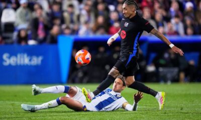 Barcelona's Raphinha, right, and Leganes' Sergio Gonzalez challenge for the ball during the Spanish La Liga soccer match between CD Leganes and Barcelona at the Butarque stadium in Leganes, outside Madrid, Spain, Saturday, April 12, 2025. (AP Photo/Manu Fernandez)
