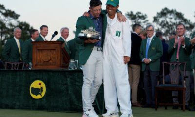 Winner Rory McIlroy, of Northern Ireland, holds the trophy with caddie Harry Diamond at the Masters golf tournament, Sunday, April 13, 2025, in Augusta, Ga. (AP Photo/Ashley Landis)